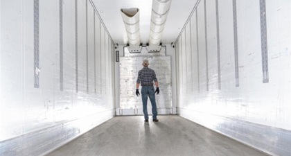 Inside view of a refrigerated shipment container with a man standing inside