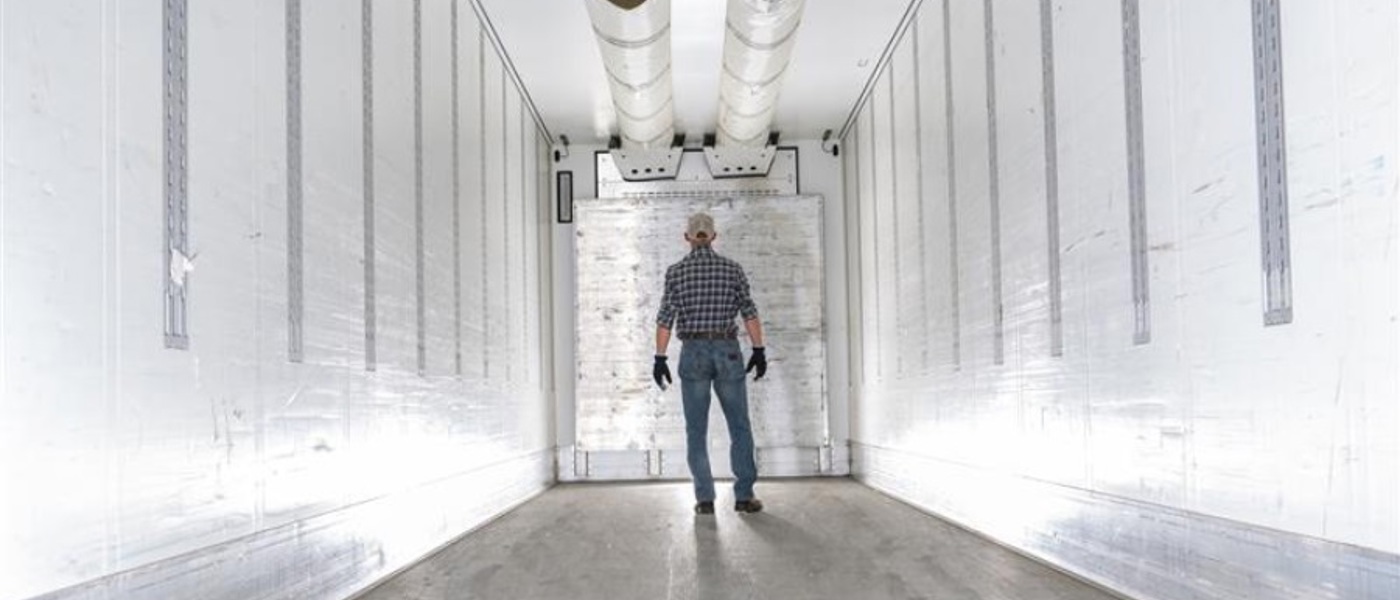 Inside view of a refrigerated shipment container with a man standing inside