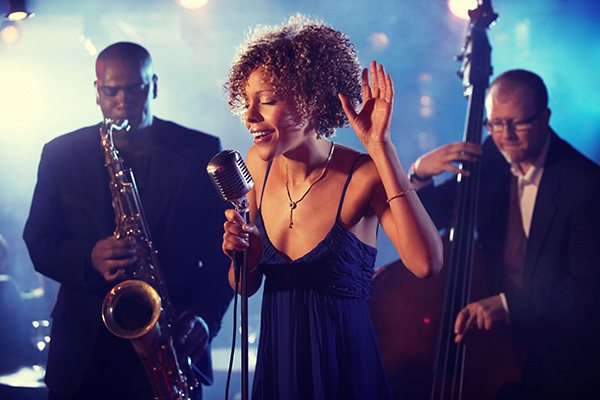 Singer At a 1950S Microphone, with a Saxophonist And a Double Bassist