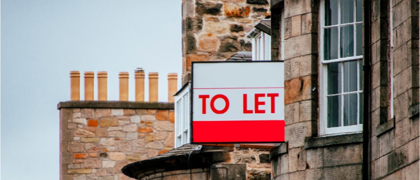 A red and white To Let sign outside a bricked building