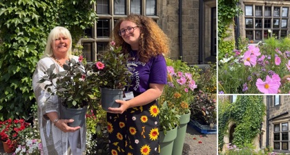 Two women hold pot plants on a sunny day