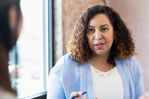 woman talking with broken wall behind her